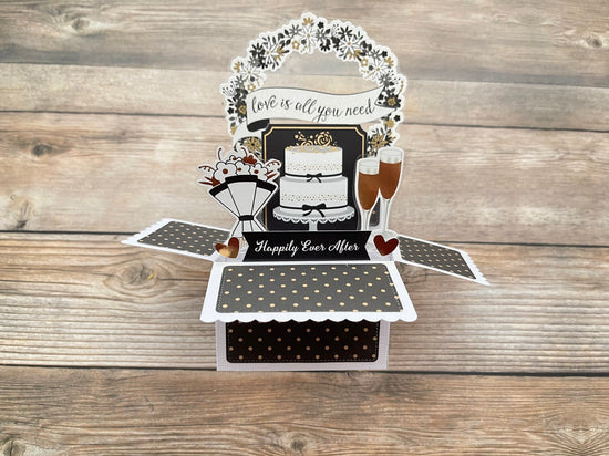 Pop-up card with wedding theme on a wooden surface
