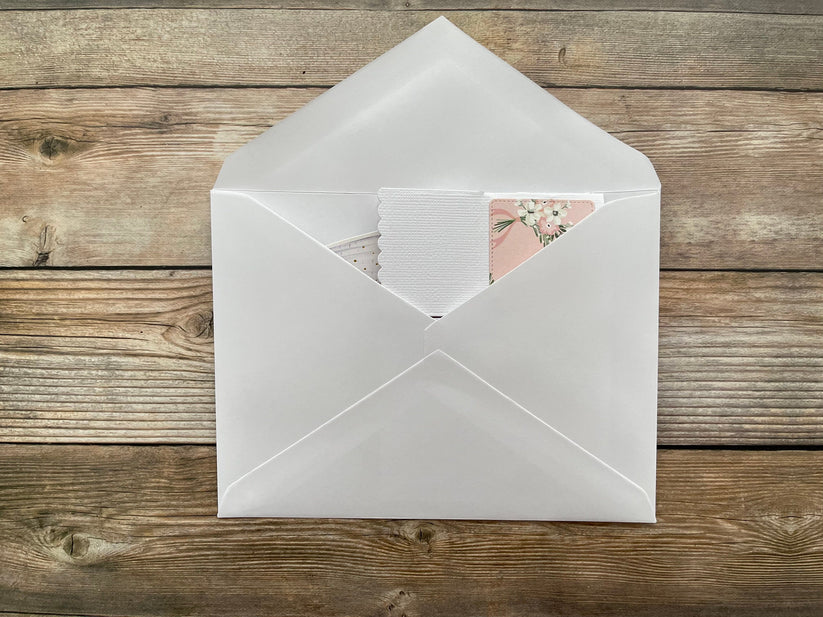 White envelope with a card inside on a wooden surface