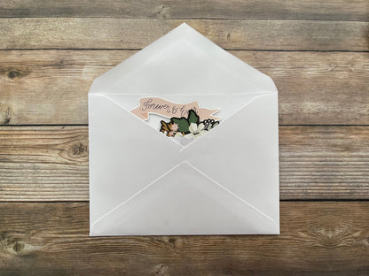 White envelope with a decorative card on a wooden surface