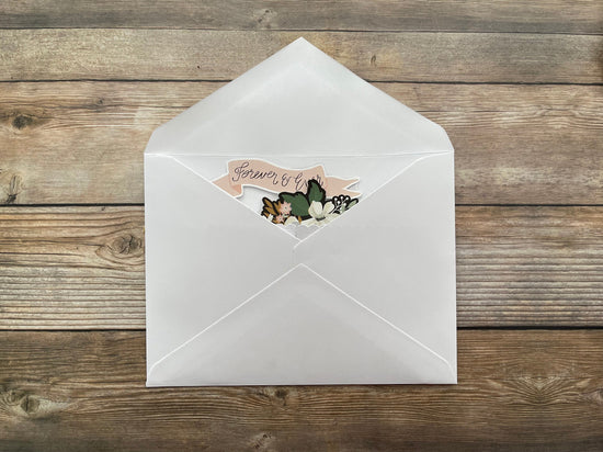 White envelope with a decorative card on a wooden surface