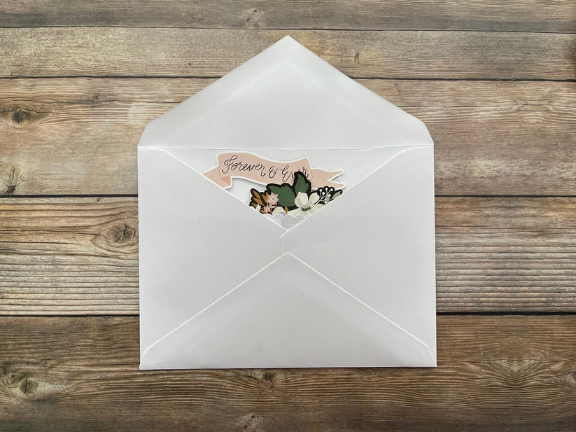 White envelope with a decorative card on a wooden surface