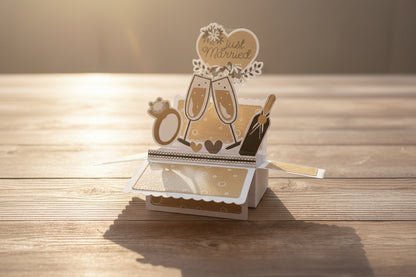 Pop-up card with 'Just Married' text and wedding-themed elements on a wooden surface