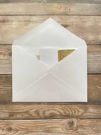 Open white envelope with a card inside on a wooden surface