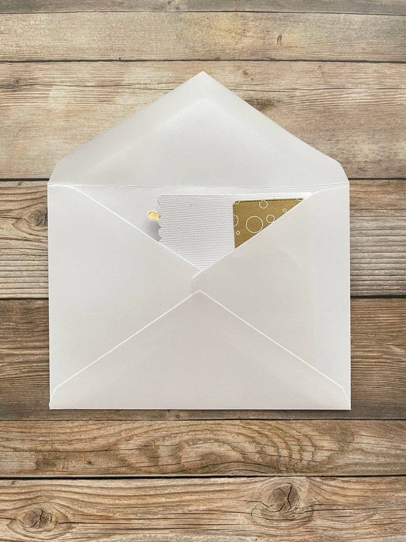 Open white envelope with a card inside on a wooden surface