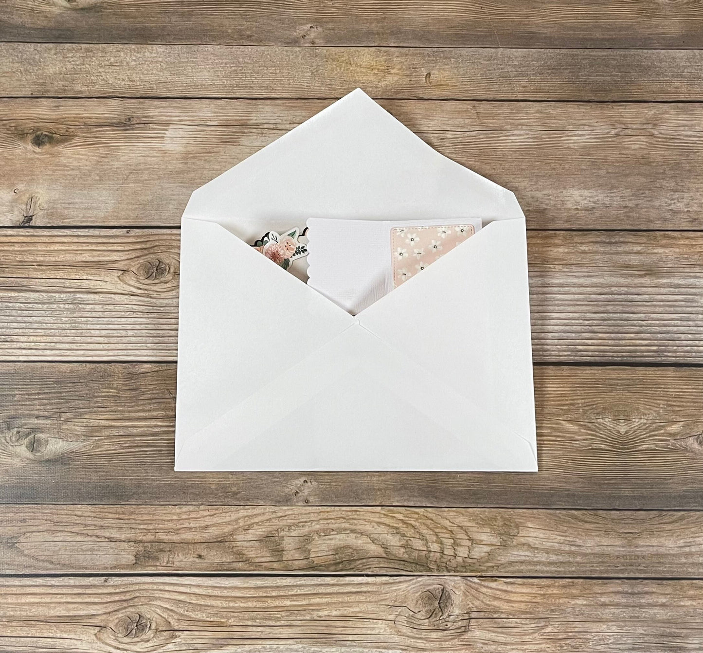 White envelope with a card on a wooden surface