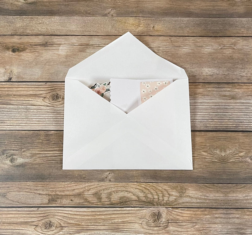 White envelope with a card on a wooden surface