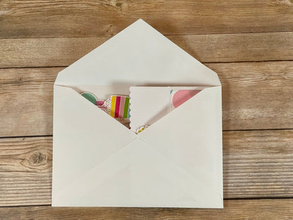 Open beige envelope with a colorful card on a wooden surface