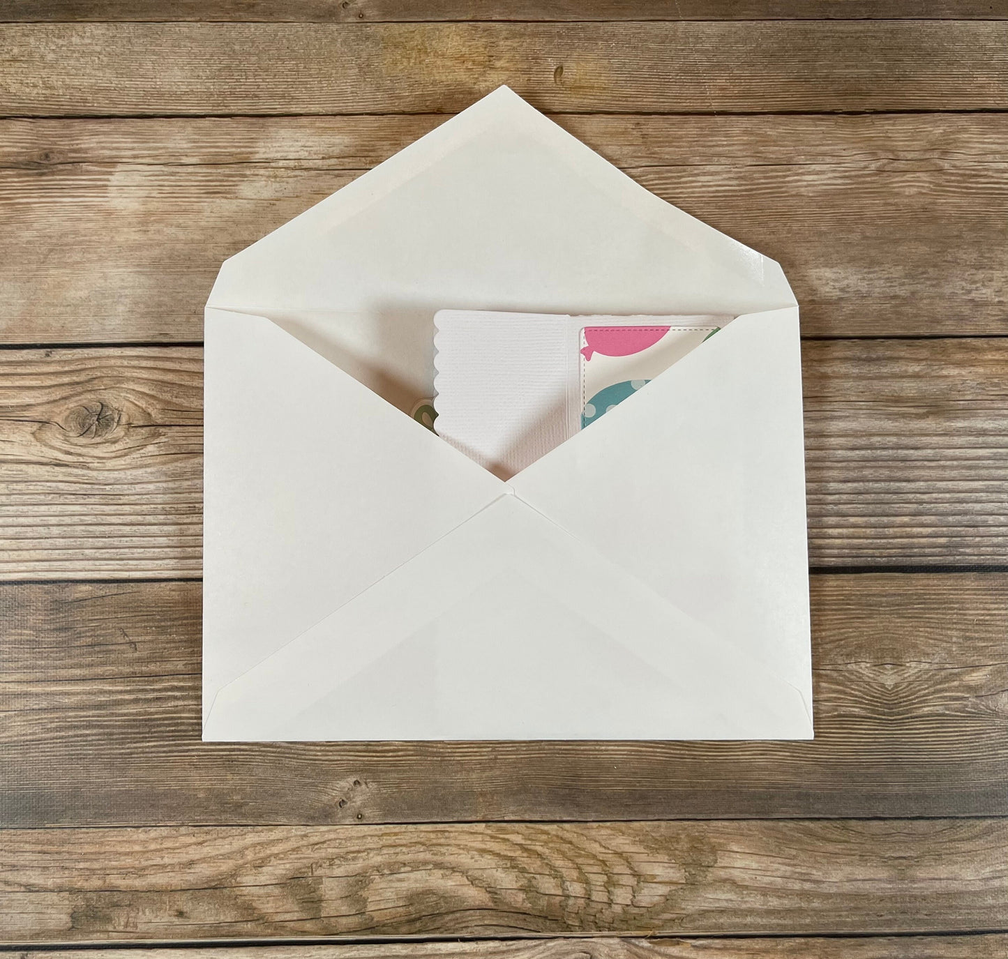 White envelope with a card on a wooden surface