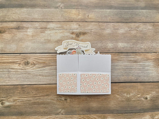 Card with 'Just Married' text on a wooden surface