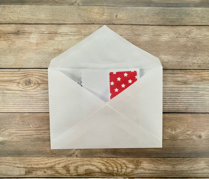 Open envelope with a red card featuring stars on a wooden surface