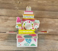 Colorful pop-up birthday card with cake design on a wooden surface