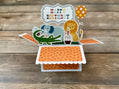Pop-up birthday card with animals and 'Happy Birthday' text on a wooden surface
