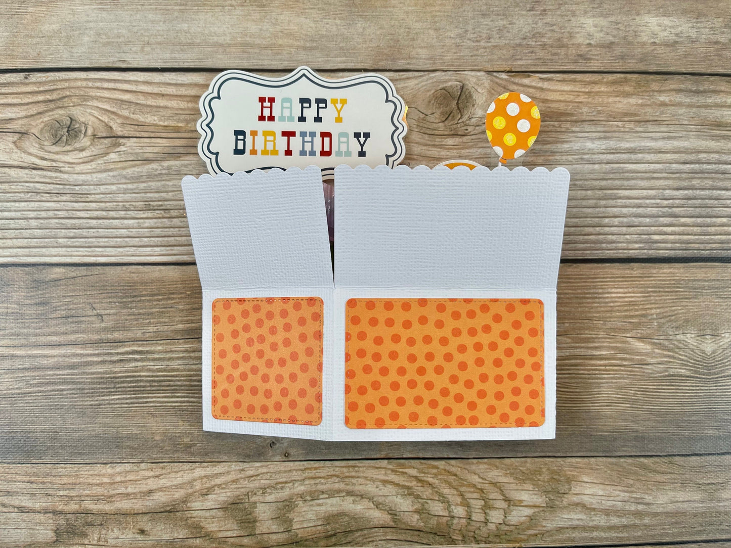 Birthday card with orange polka dot design on a wooden surface