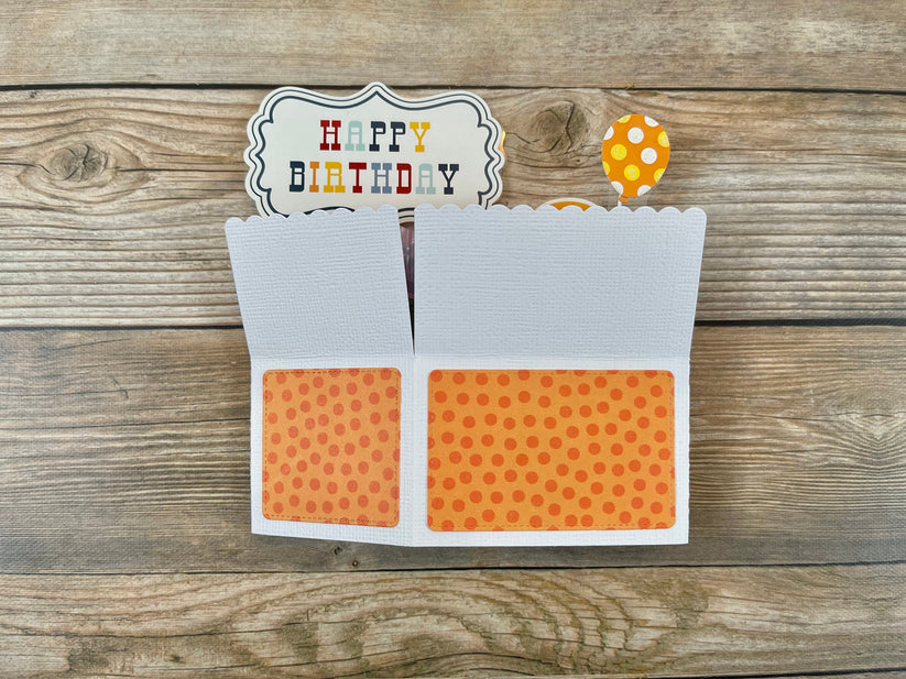 Birthday card with orange polka dot design on a wooden surface