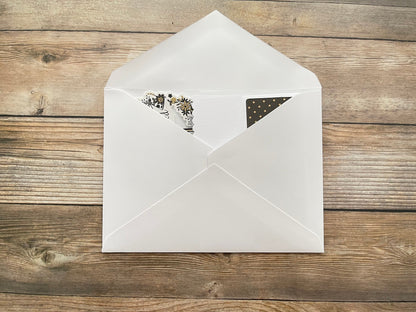 White envelope with stationery items on a wooden surface
