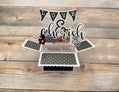 Pop-up box style greeting card with 'Love & Cherish' text on a wooden surface