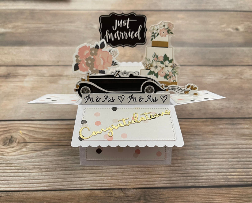 Pop-up card with wedding car and 'Just Married' text on a wooden background