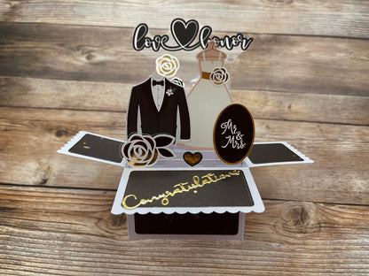 Pop-up card with wedding-themed elements on a wooden background