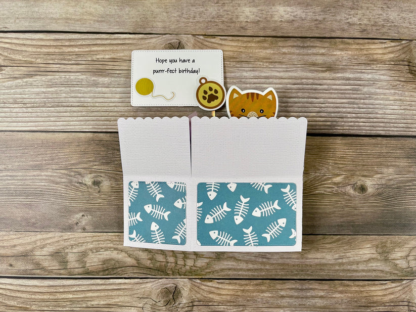 Card with cat-themed illustrations on a wooden surface