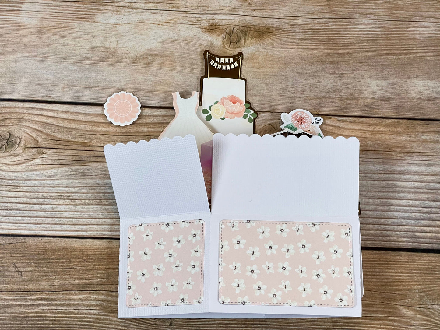 Open card with floral design on a wooden surface