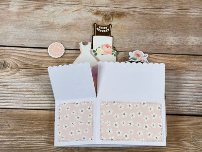 Open card with floral design on a wooden surface