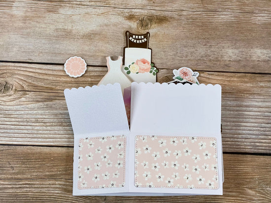Open card with floral design on a wooden surface