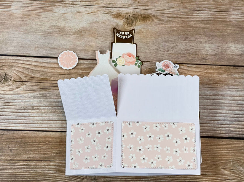 Open card with floral design on a wooden surface