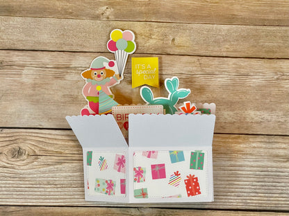 Decorative card with clown, balloons, and cactus on a wooden background