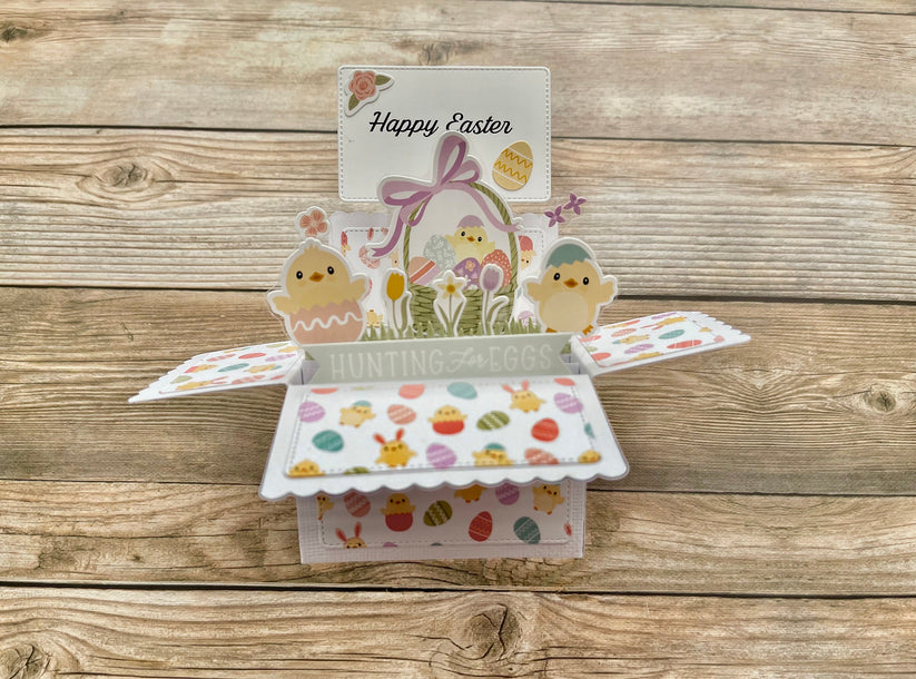 Easter-themed pop-up card with chicks and eggs on a wooden surface