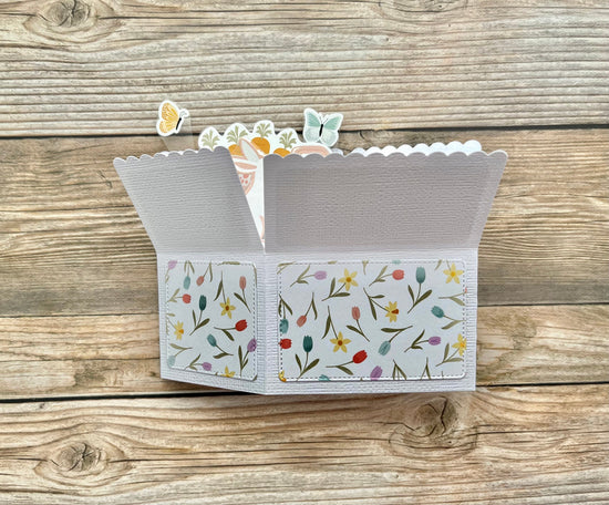 Floral patterned card with a scalloped edge on a wooden surface