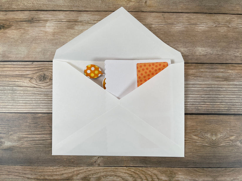 Open white envelope with a card inside on a wooden surface