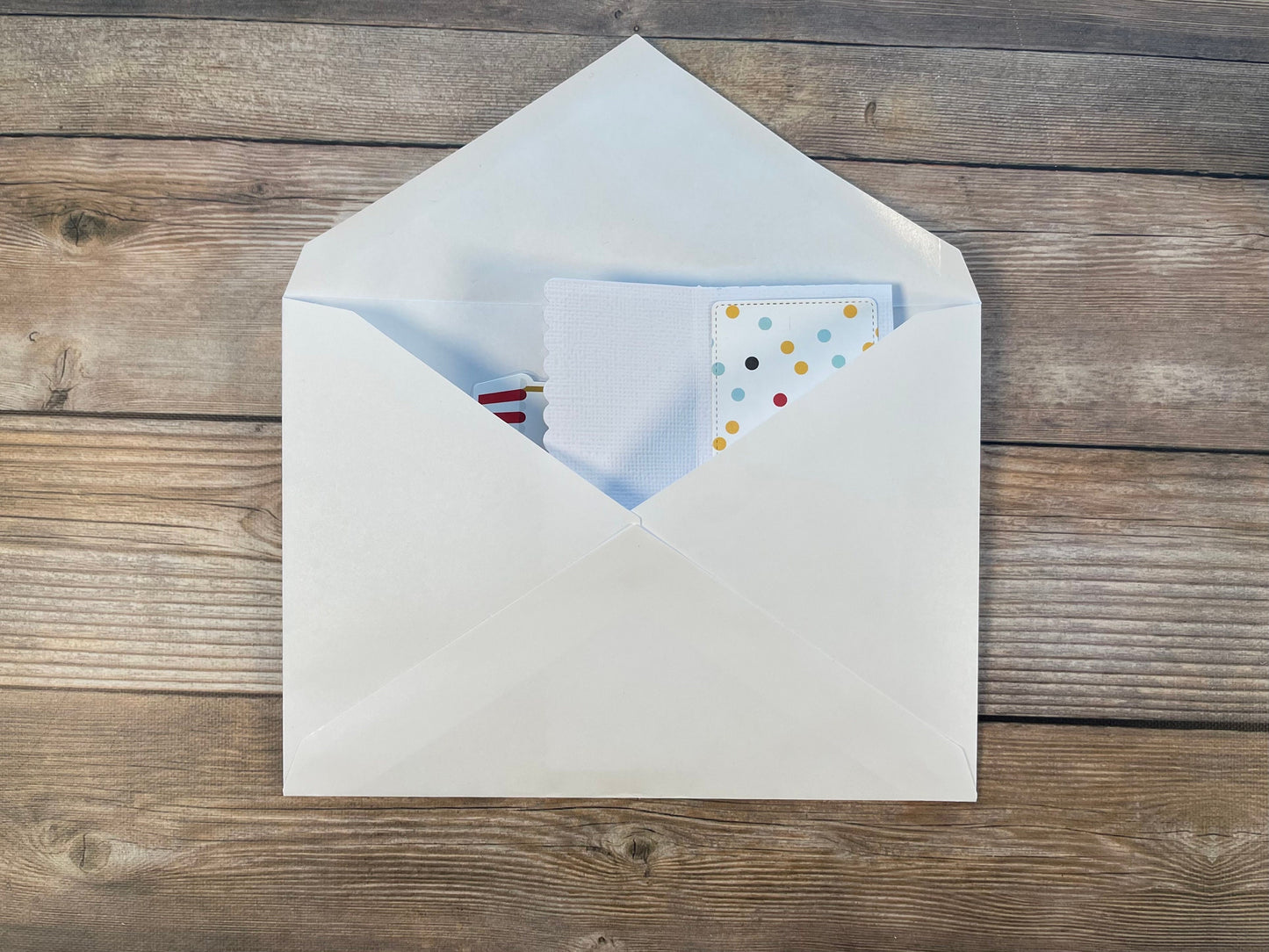 Open envelope with a letter inside on a wooden surface