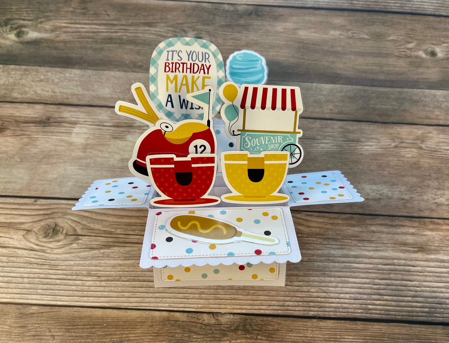 Colorful birthday pop-up card on a wooden surface