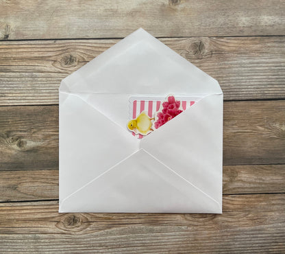 Open white envelope with a decorative card on a wooden surface