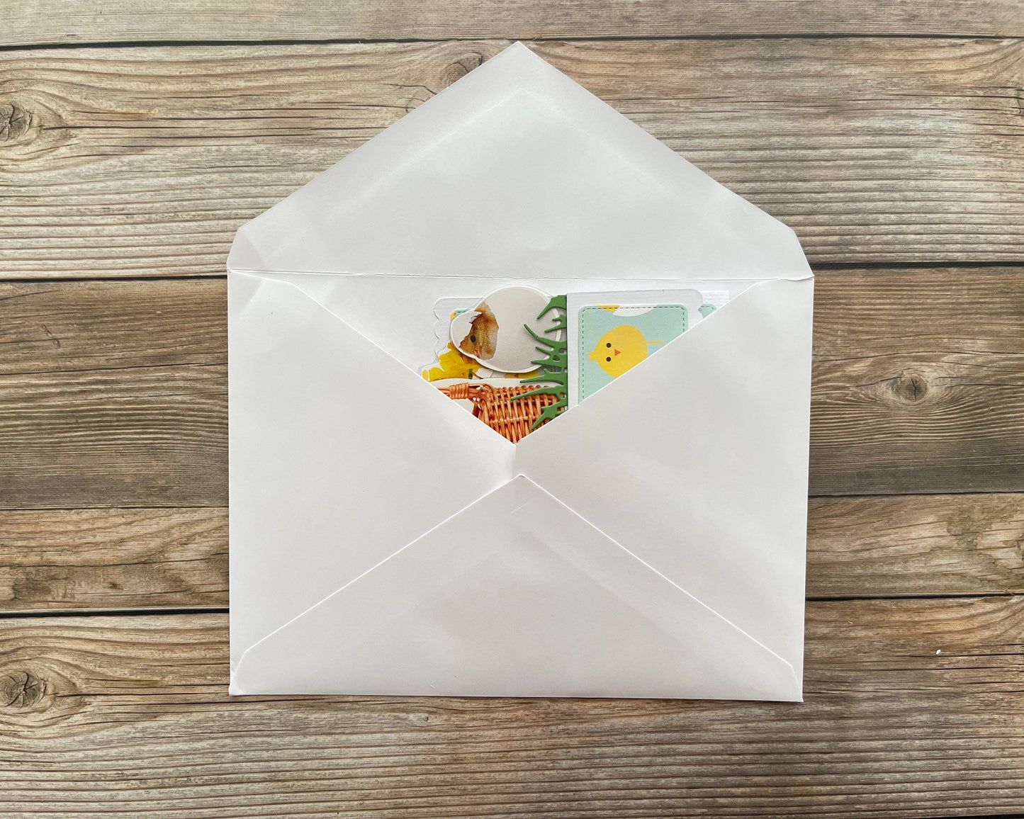 White envelope with a colorful card on a wooden surface