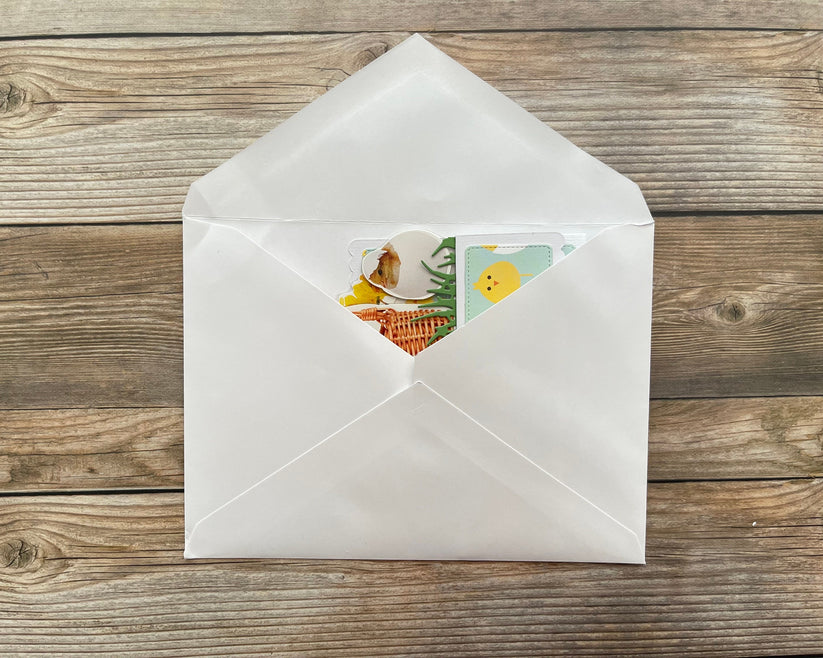 White envelope with a colorful card on a wooden surface