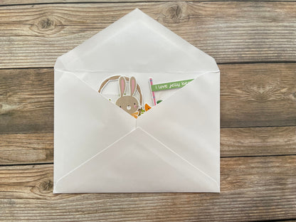White envelope with a card featuring a rabbit illustration on a wooden surface