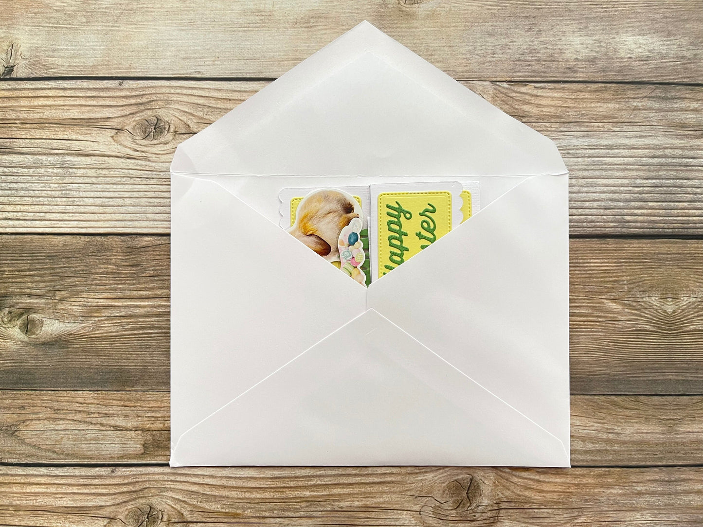 White envelope with a card inside on a wooden surface