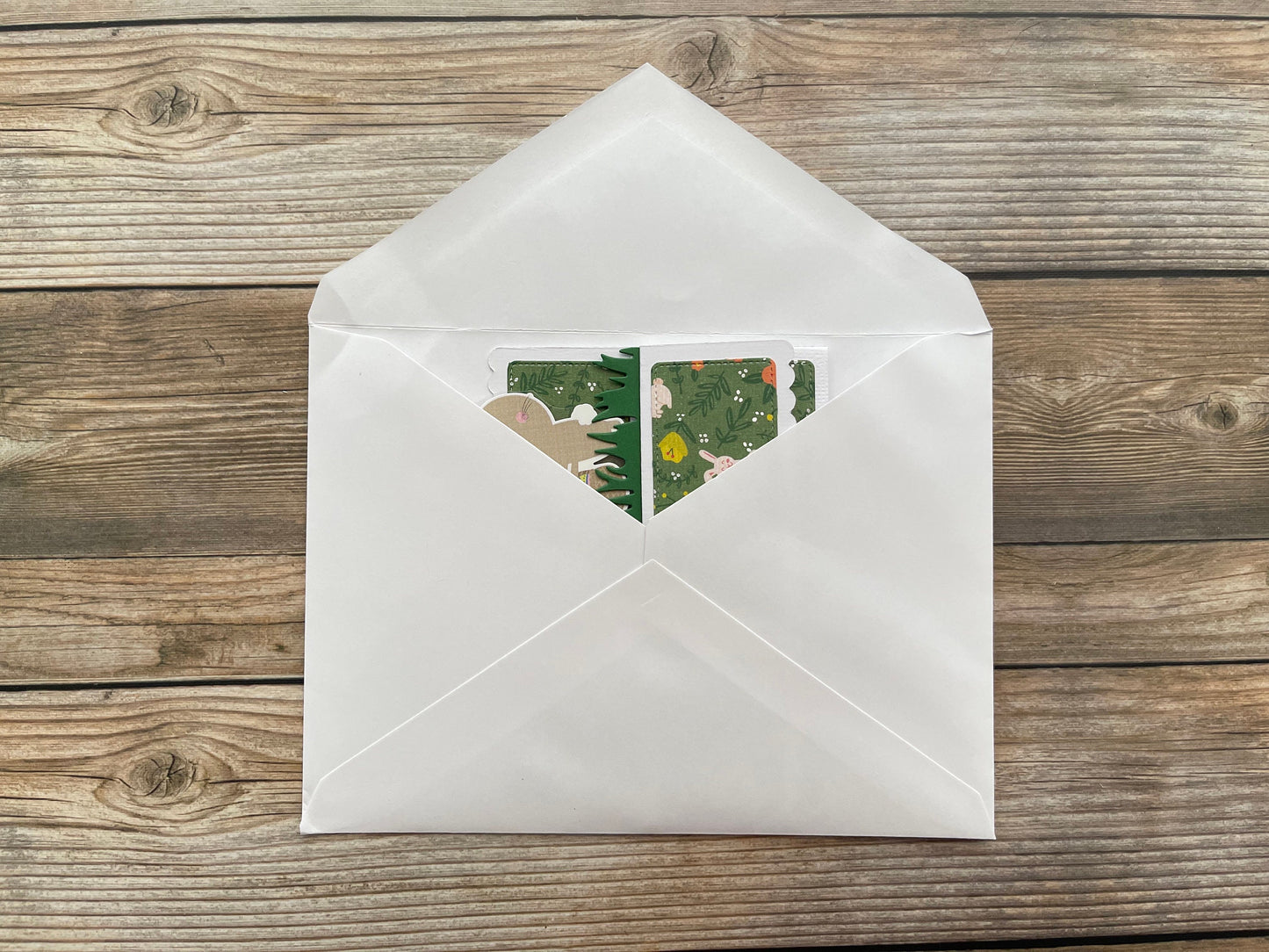 White envelope with a floral design on a wooden surface