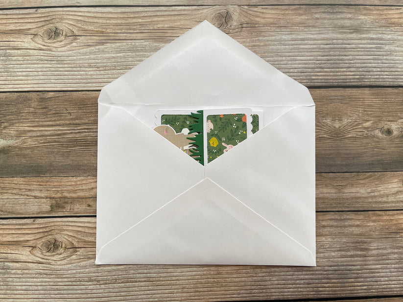 White envelope with a floral design on a wooden surface