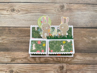Card with rabbit illustrations on a wooden surface