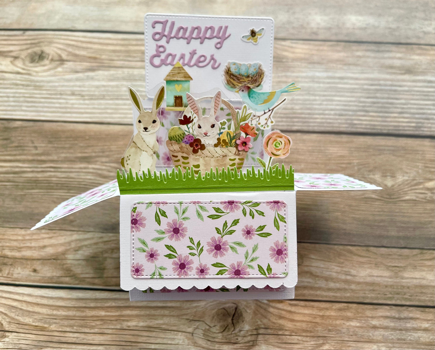Pop-up Easter card with rabbit, chick, and flowers on a wooden background