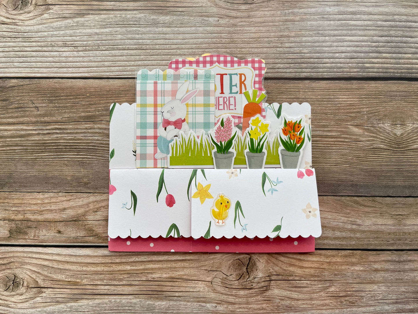 Colorful card with floral and Easter designs on a wooden surface