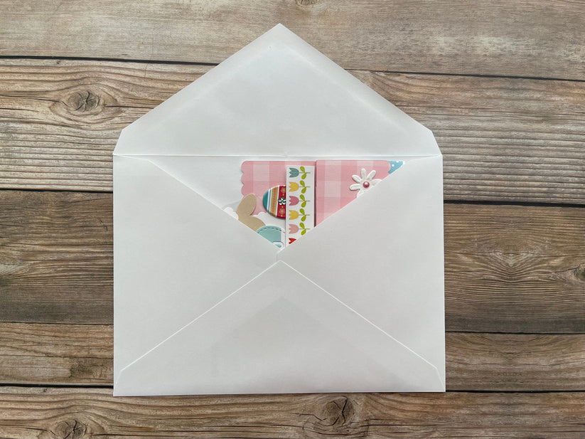 White envelope with a colorful card inside on a wooden surface
