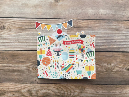 Colorful birthday-themed greeting card with decorative elements on a wooden surface