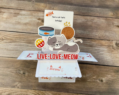 Pop-up card with cat-themed elements and 'Live Love Meow' text on a wooden surface