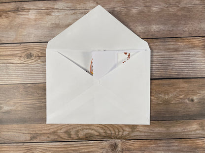 White envelope with a letter inside on a wooden surface