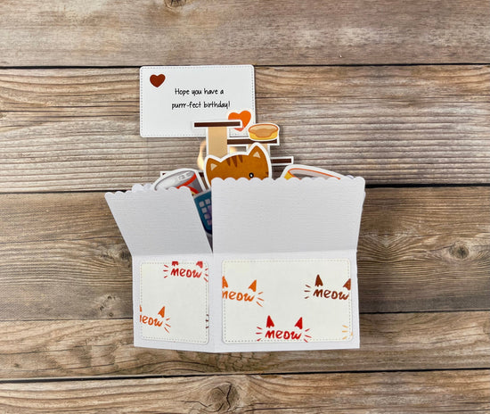 Cat-themed birthday card with envelope on a wooden surface