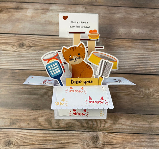 Pop-up card with a cat design on a wooden surface