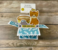 Cat-themed card with fish pattern on a wooden surface